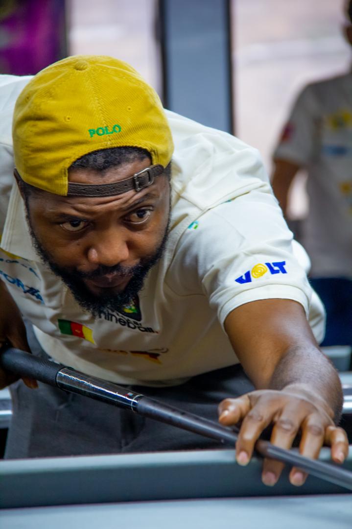 Bih Yannick prépare un coup à la table de billard