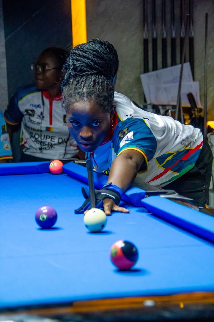 Suzy Amougou prépare un coup sur une table de billard bleue